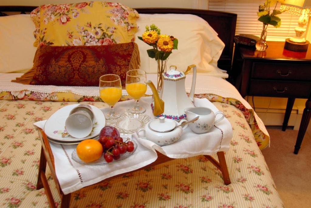 a breakfast tray with fruit and juice on a bed at Arbor View House Bed and Breakfast in East Marion