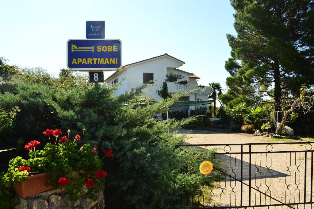 a house with a sign in front of a yard at Apartments Stivic in Pinezici