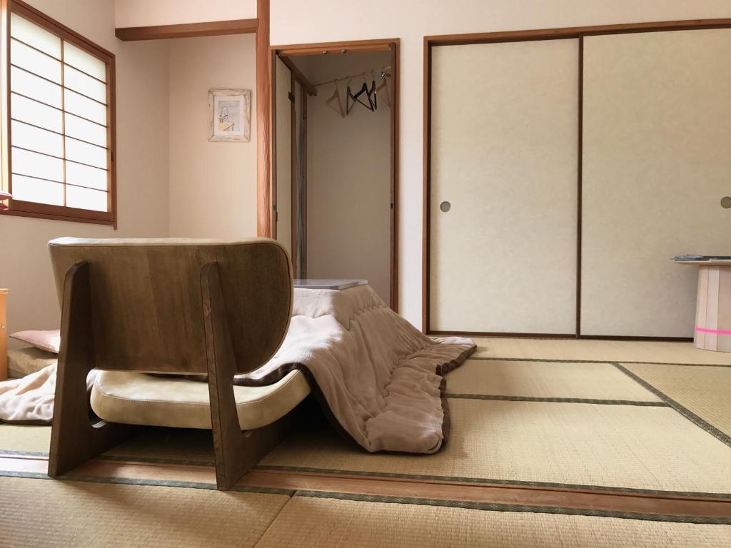 a living room with a chair and a door at Sayama Aesthetics School in Osakasayama