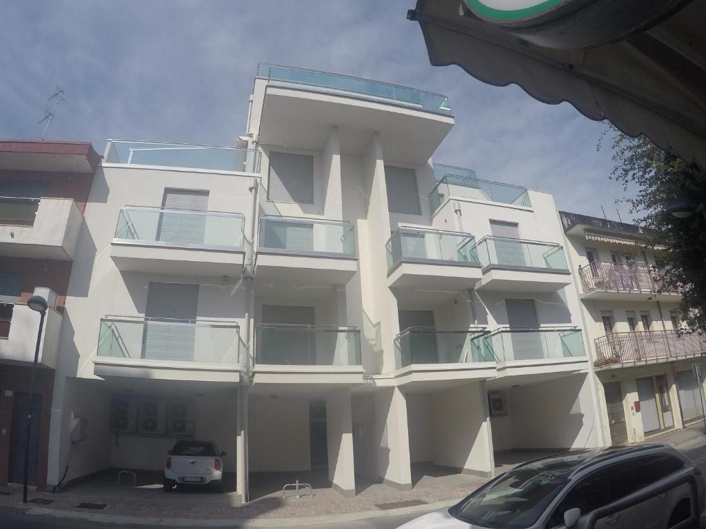 un edificio blanco con balcones en un lateral en Suite Marconi - Agenzia Cocal en Caorle