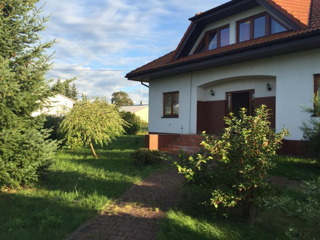 a white house with a pathway in the yard at Landhaus mit Garten in Szczecin