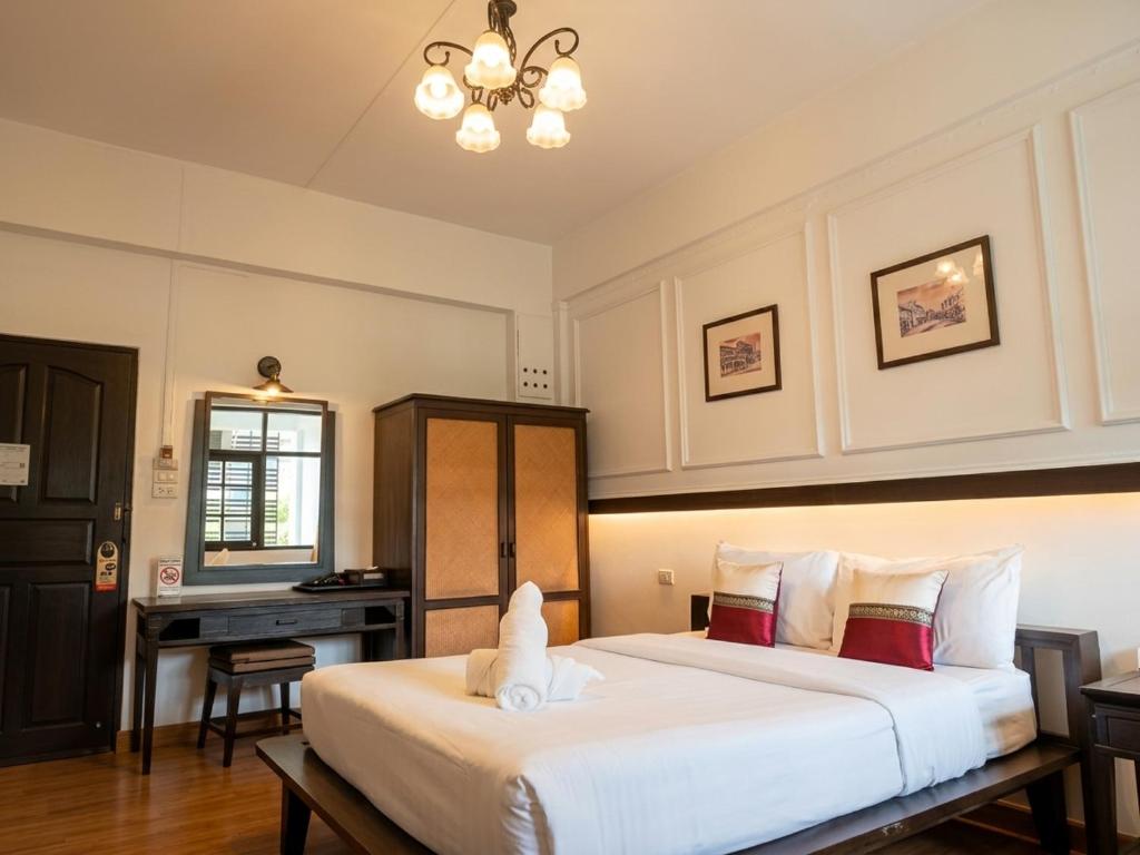 A bright double bedroom with a large bed, writing desk and wardrobe.