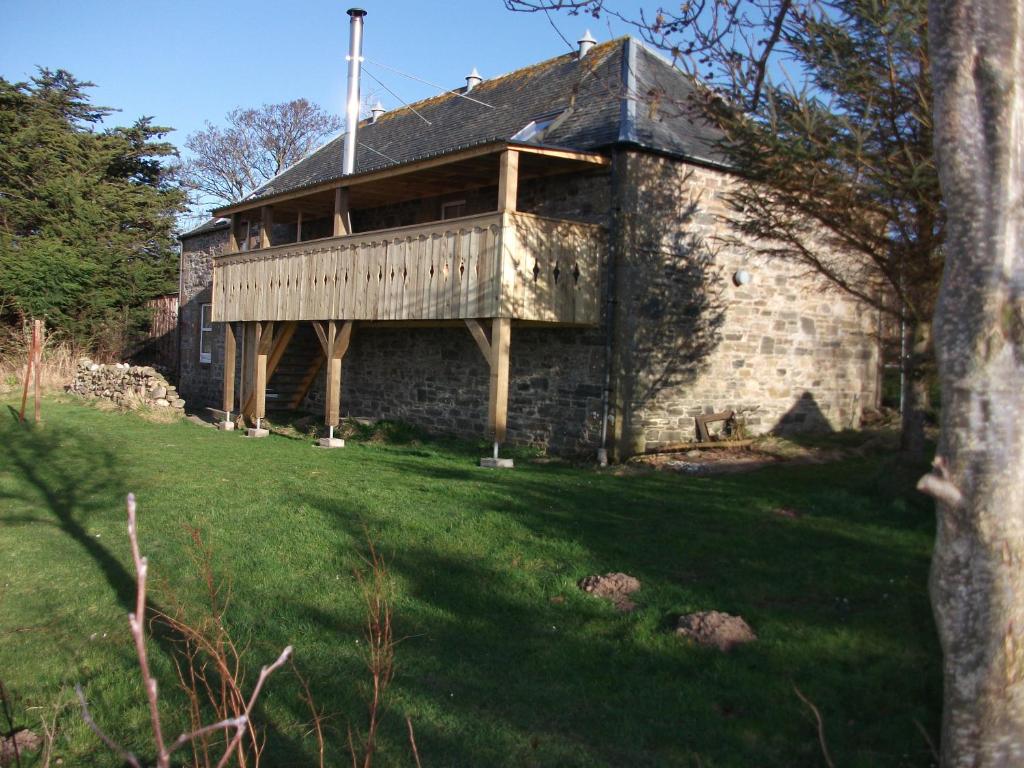 バッキーにあるThe Granaryの芝生の上に出入りする古い石造りの家