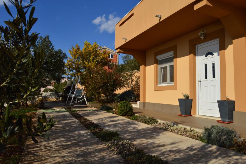 ein Haus mit einer weißen Tür und einem Gehweg in der Unterkunft Apartment sun is shining in Rogoznica