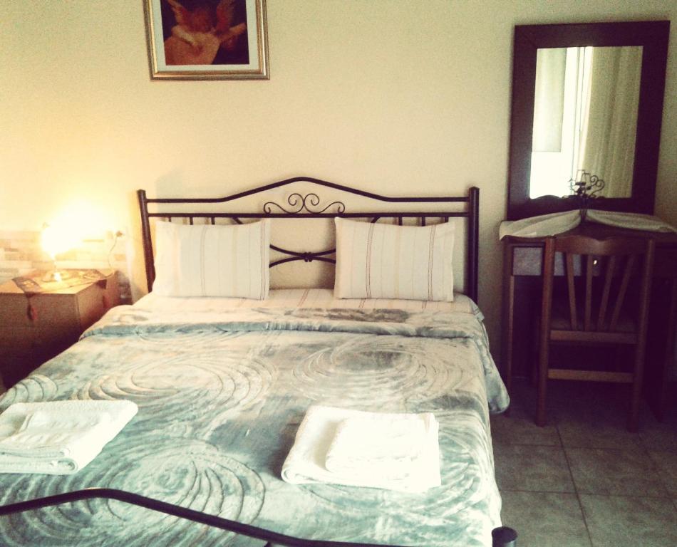 1 dormitorio con 1 cama con 2 toallas en Guesthouse Adonis, en Kato Loutraki