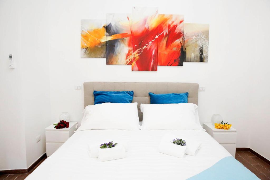 ローマにあるCastel Sant Angelo's Harmonious Apartmentの白いベッドと壁に絵画が飾られたベッドルーム1室