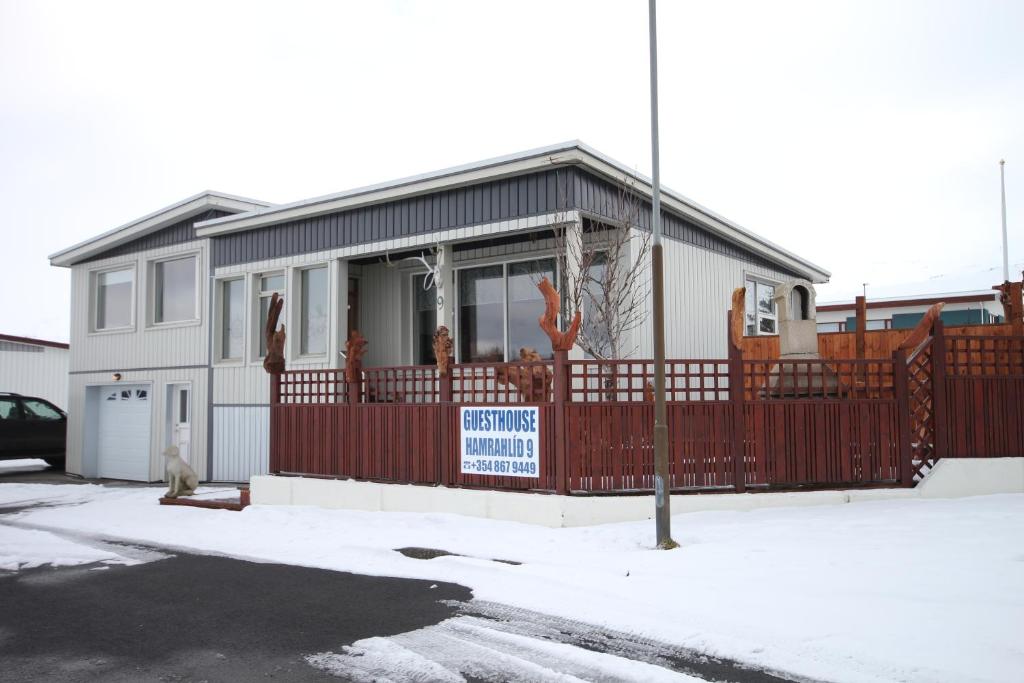 a house with a red fence in front of it at Hamrahlíð 9 Guesthouse in Grundarfjordur