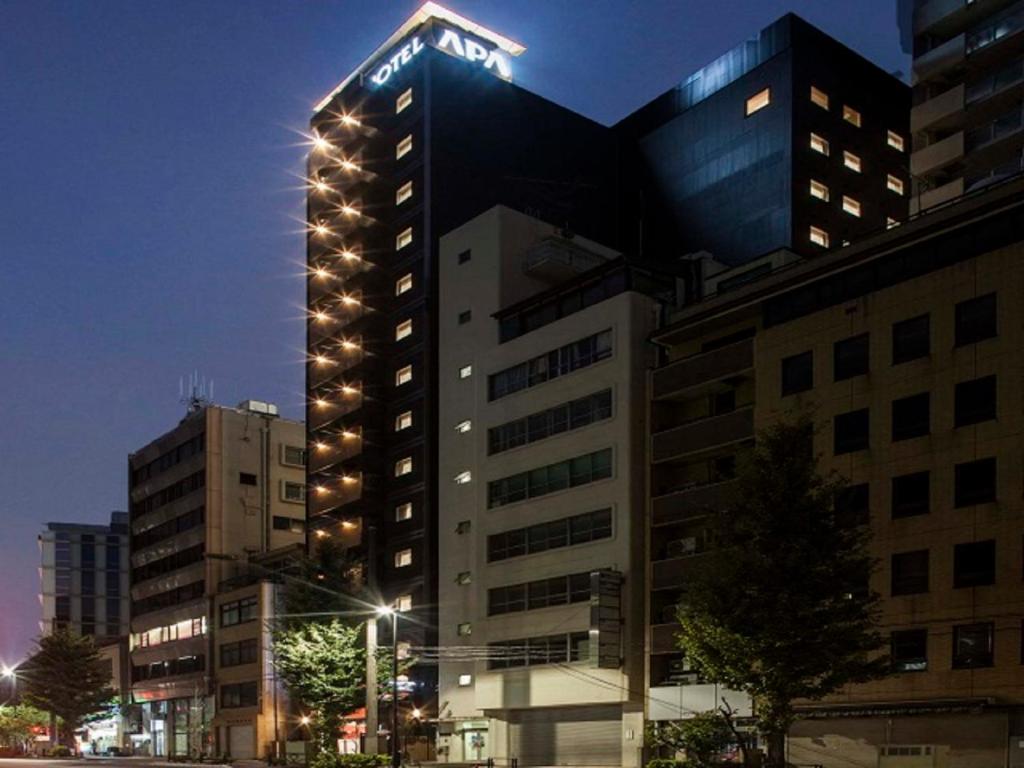 um edifício alto com um sinal em cima em APA Hotel Ochanomizu-Ekikita em Tóquio