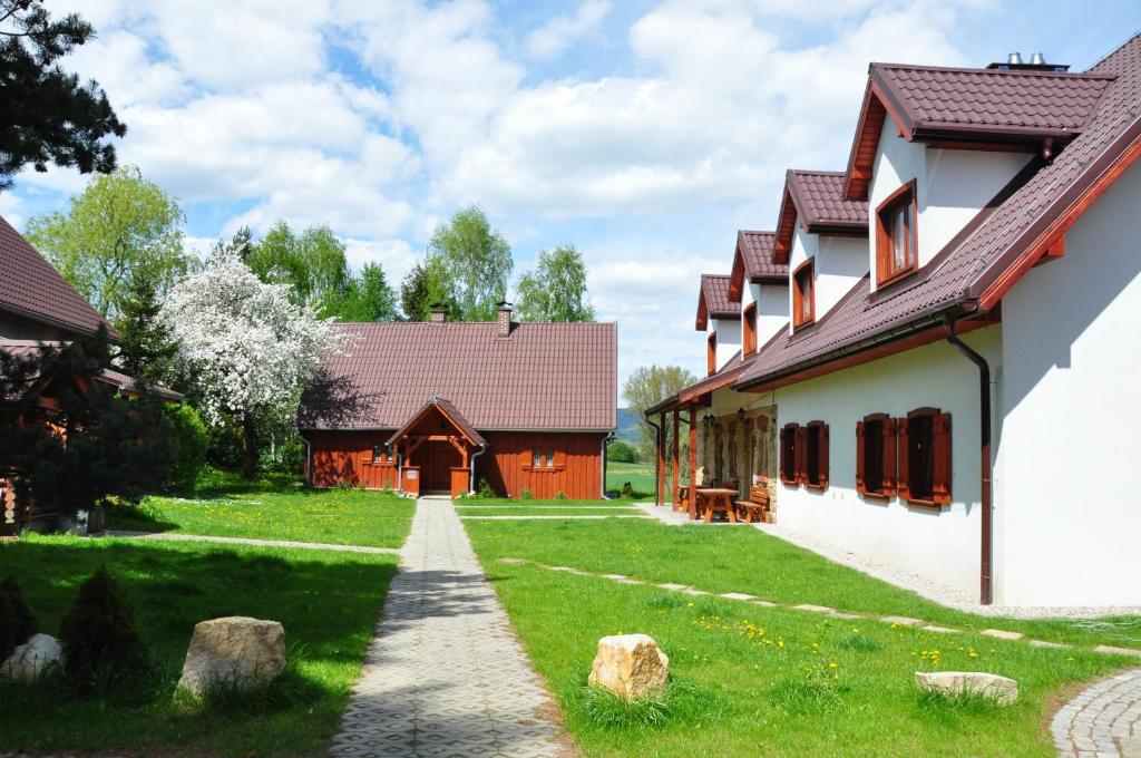 een pad naar een huis en een schuur bij Jasminowe Wzgorze in Wilkanów