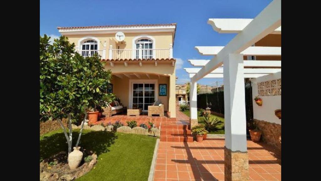 een groot huis met een patio en een tuin bij Casa Paraiso in Caleta De Fuste