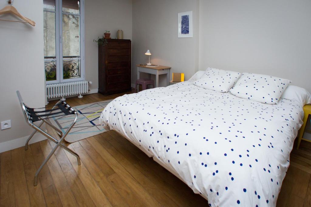 a bedroom with a bed and a chair in it at Chambre d'hôte parisienne in Paris