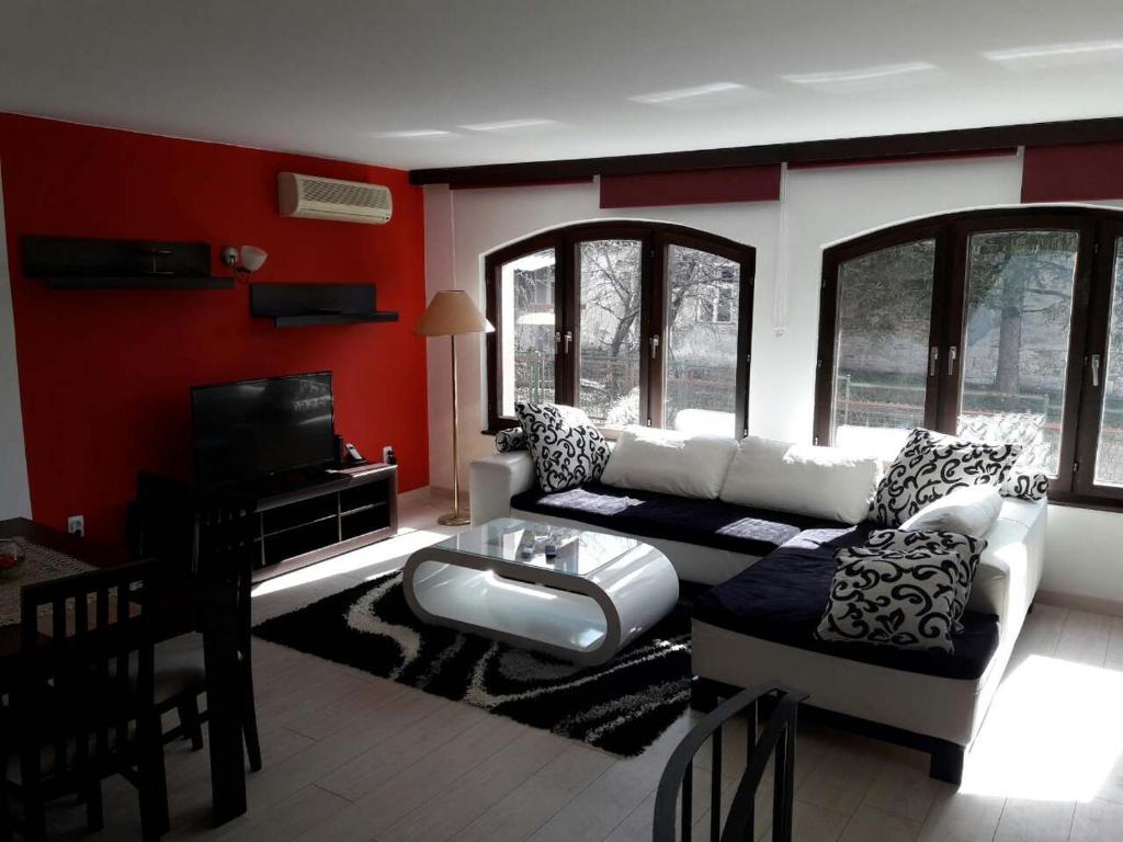 a living room with a white couch and red walls at Supilova Apartments in Belgrade