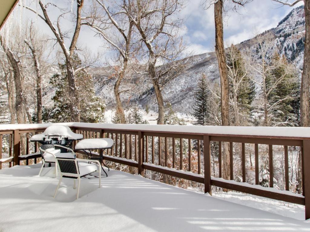 einen Balkon mit einem Tisch und Stühlen im Schnee in der Unterkunft Mt. Sopris Cabin at Filoha Meadows in Redstone