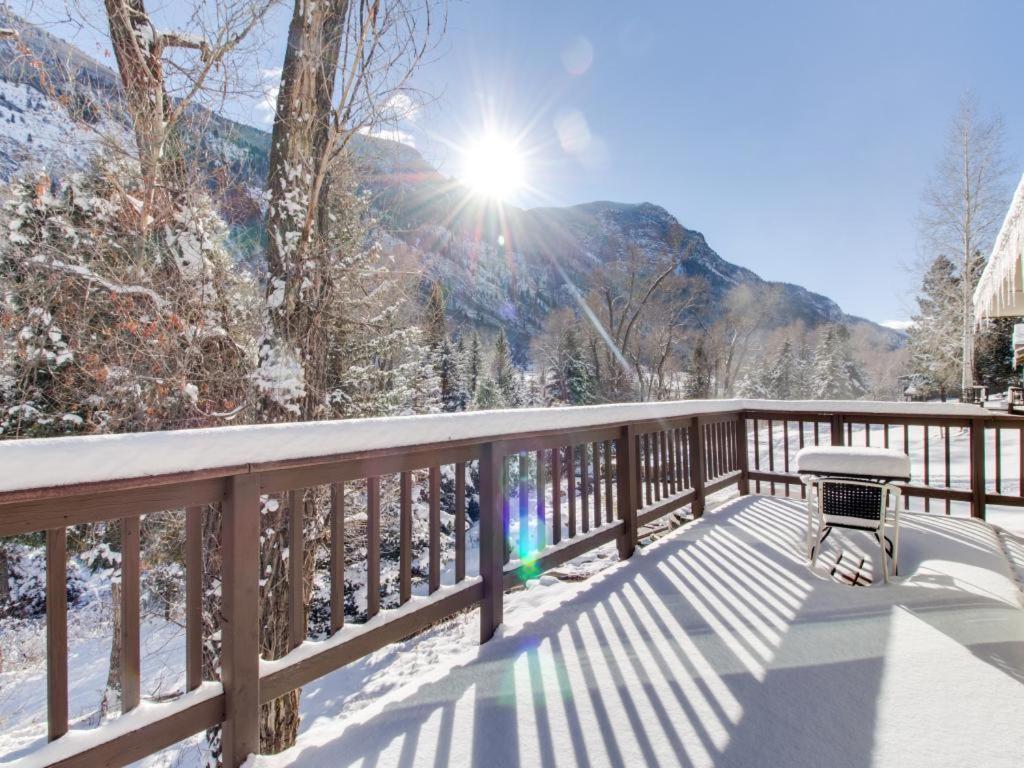 una terraza de madera con un banco en una montaña cubierta de nieve en Elephant Mountain Cabin at Filoha Meadows, en Redstone