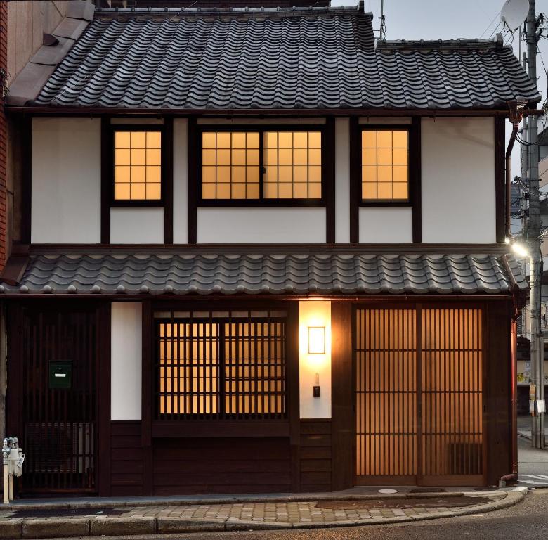 ein japanisches Haus mit einem schwarz-weißen Gebäude in der Unterkunft Machiya Kamo River 7 in Kyoto