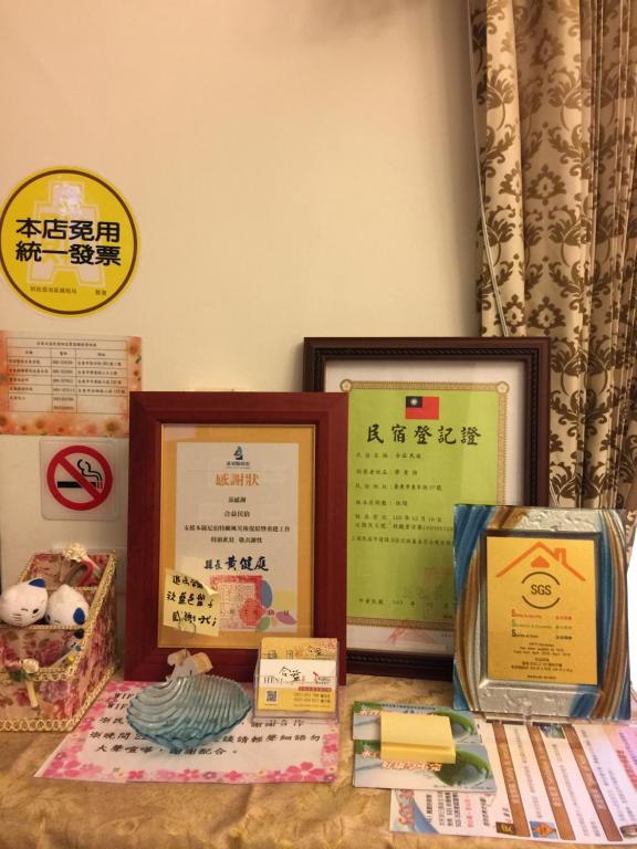 a table topped with framed certificates and other signs at Heyi B&amp;B in Taitung City