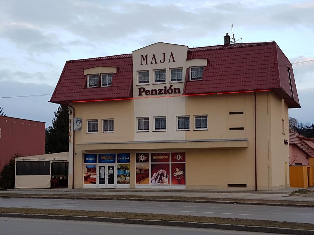 a building with a red roof on a street at Penzion Maja in Martin