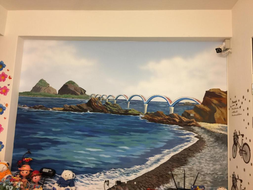 a mural of a bridge over the water on a wall at Heyi B&amp;B in Taitung City