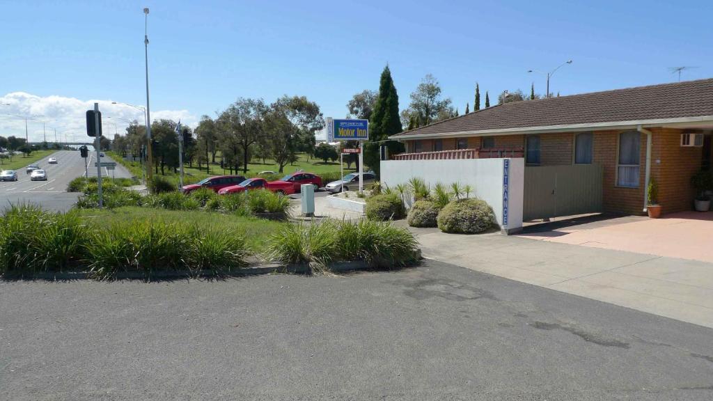 un bâtiment avec des voitures garées dans un parking dans l'établissement Rippleside Park Motor Inn, à Geelong