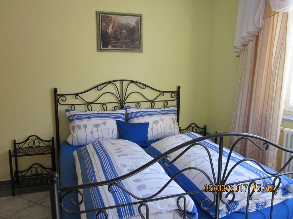 Schlafzimmer mit einem Bett mit blauer und weißer Bettwäsche in der Unterkunft Luba Rube in Rust