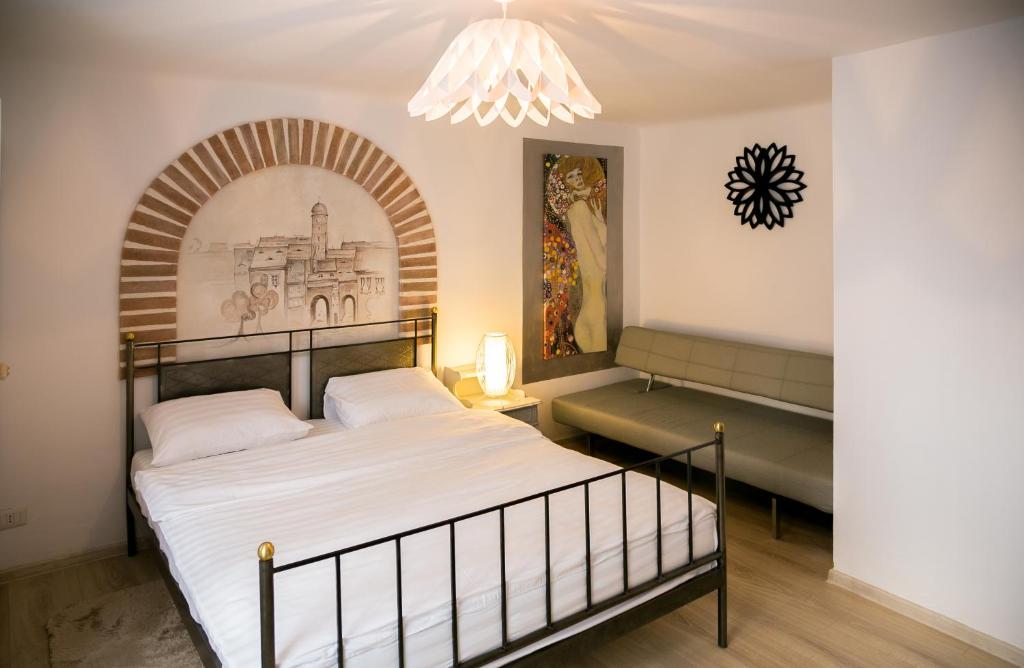 a bedroom with a bed and a chandelier at Hegel Apartment in Sibiu