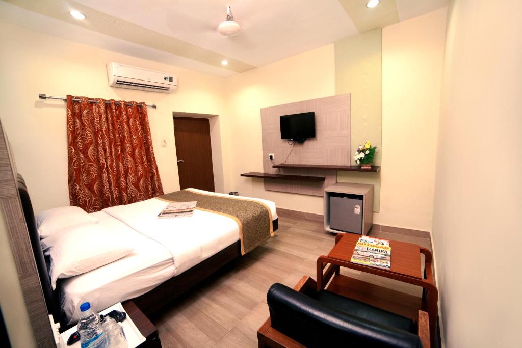 a hotel room with a bed and a tv at Taj Mahal Hotel Abids in Hyderabad