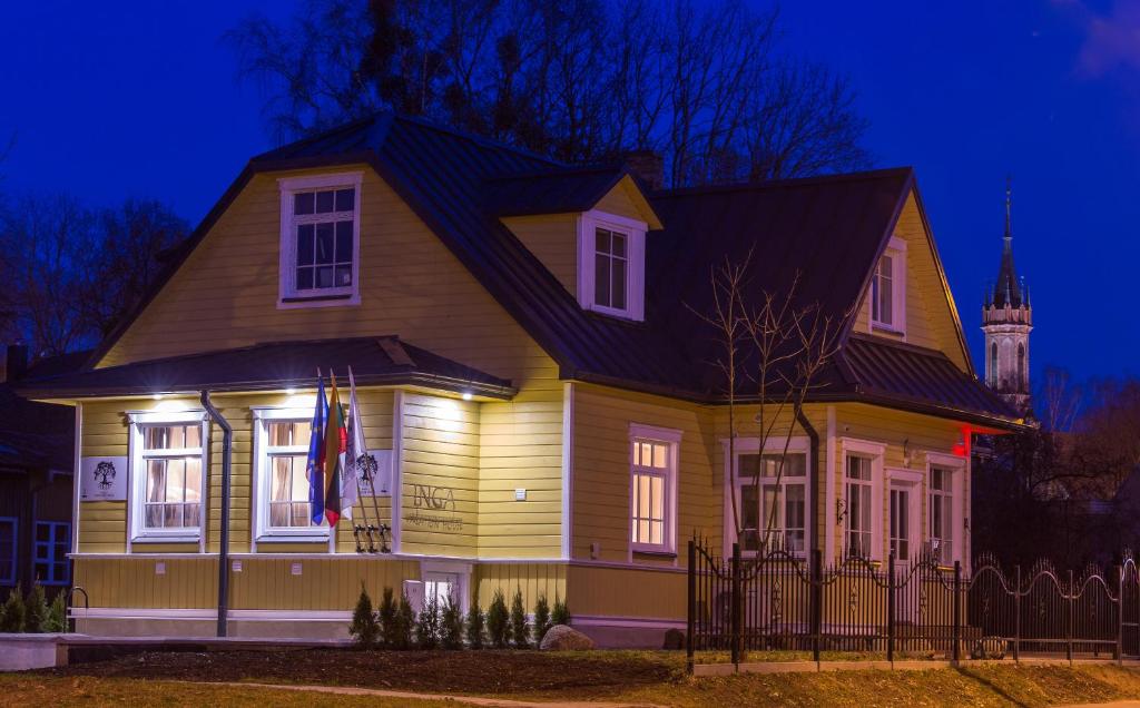 una casa con luces en la parte delantera de la noche en Inga Vacation House en Druskininkai