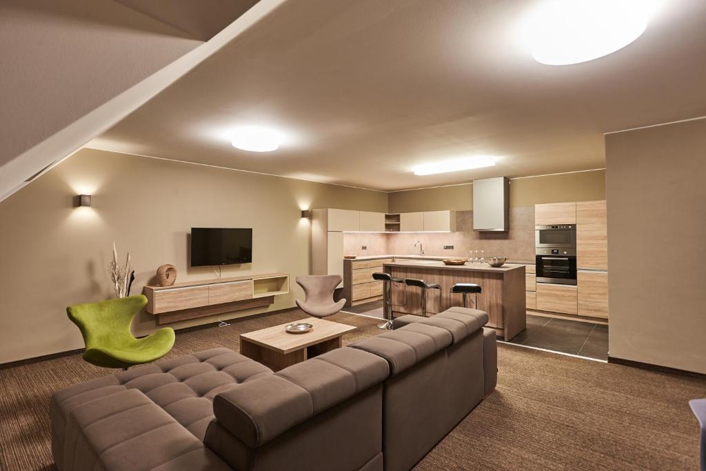 a living room with a couch and a kitchen at Apartmány Volarik in Mikulov