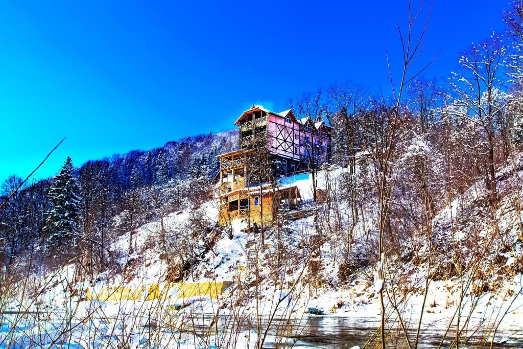 a building on the side of a hill in the snow at Gutsulska rodzynka in Yaremche