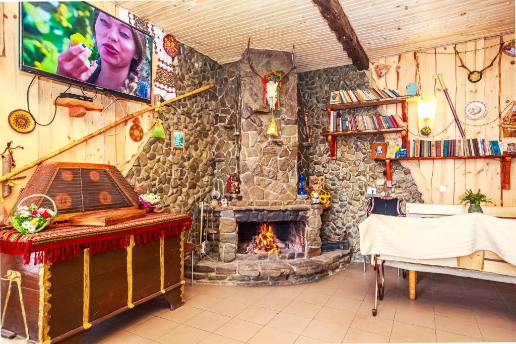 a living room with a stone fireplace and a table at Gutsulska rodzynka in Yaremche