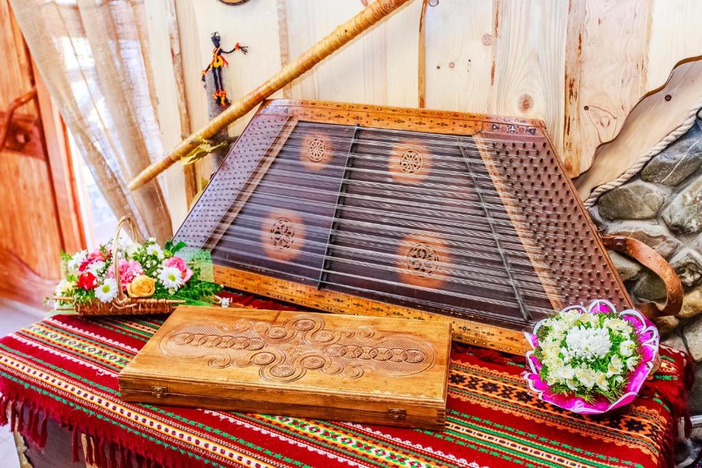 a wooden plaque on a table with two flowers at Gutsulska rodzynka in Yaremche