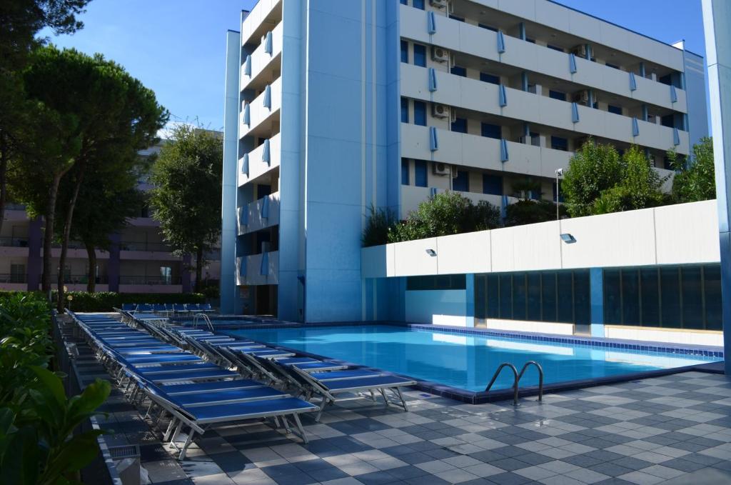 a swimming pool in front of a building at Residence Acapulco in Bibione