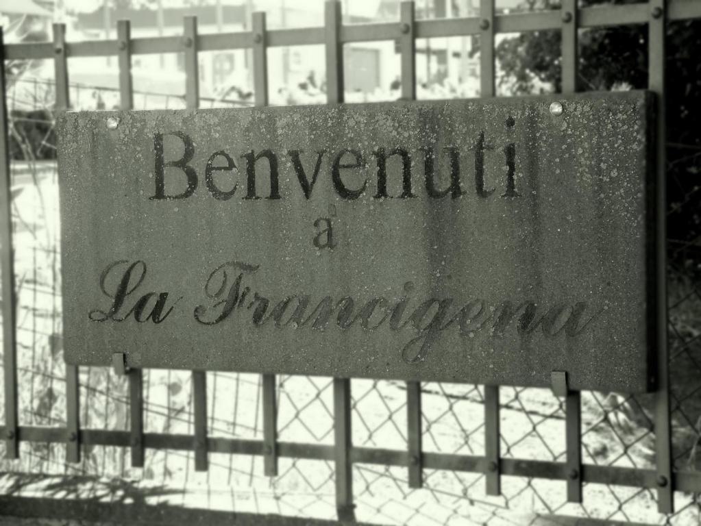 una señal en una valla con las palabras Benvenuto a la huracán en La Francigena, en Staggia