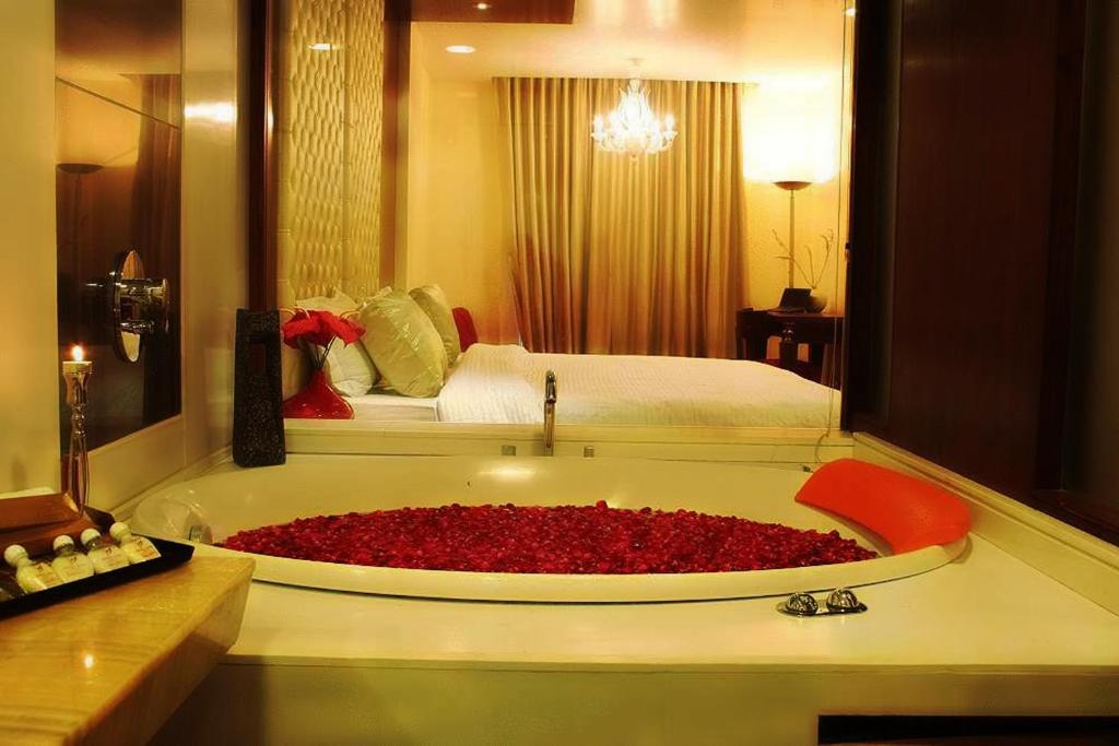 ein Badezimmer mit einer Badewanne mit roten Blumen in der Unterkunft Hotel Aura - New Delhi Railway Station in Neu-Delhi