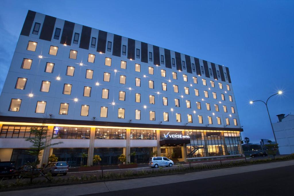 a building with a white car parked in front of it at Verse Hotel Cirebon in Cirebon