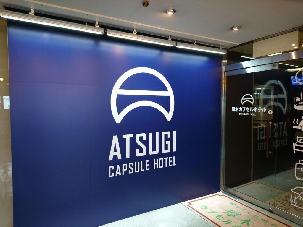 un cartello per un hub di servizio di atsu di Atsugi Capsule Hotel a Atsugi