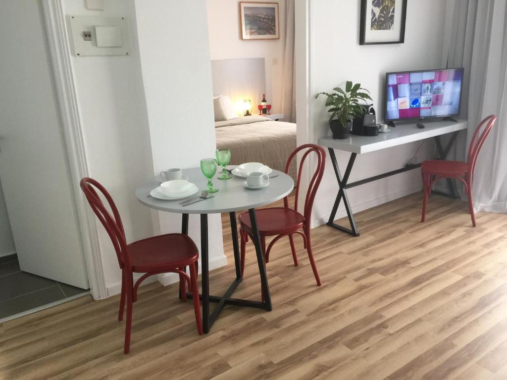 a dining room with a table and chairs and a bed at Pasithea Holiday Apartments in Larnaka