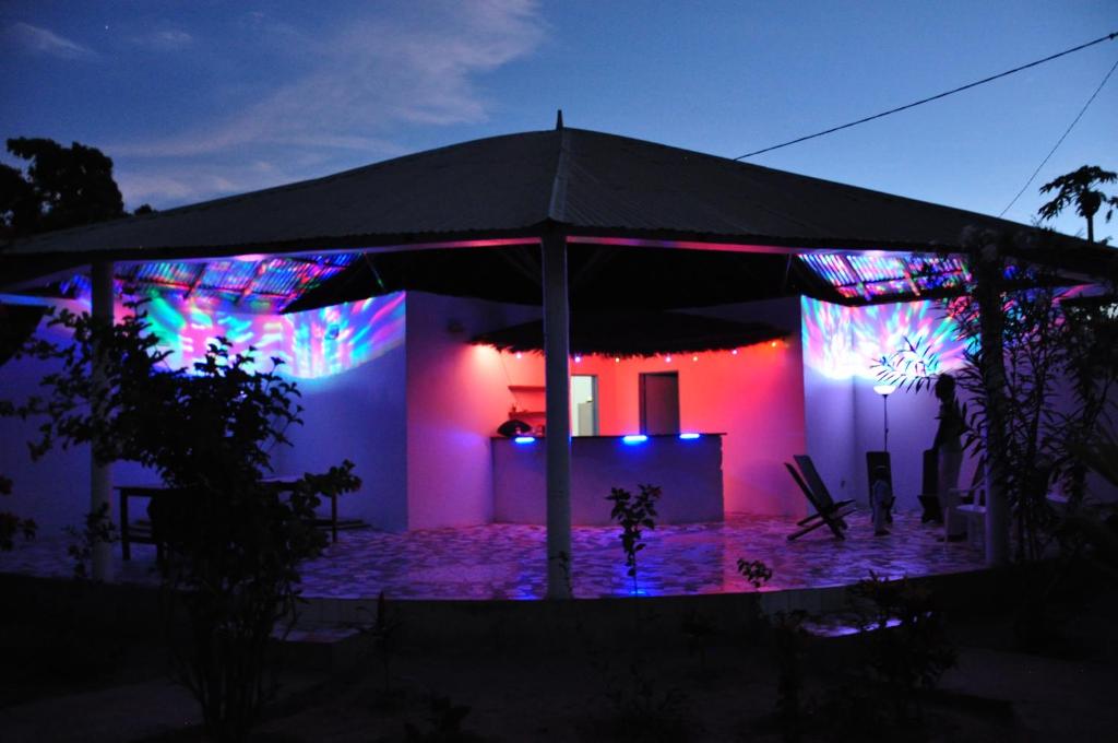 Guesthouse Yonol في Abémé: منزل به أضواء أرجوانية وزرقاء