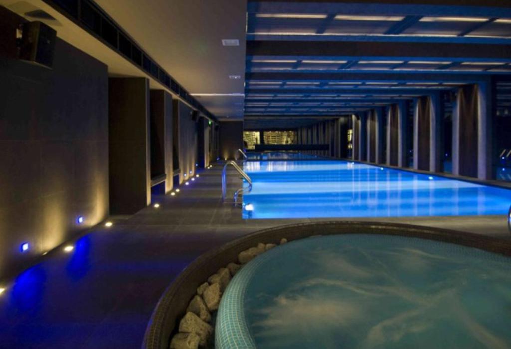 a large swimming pool with a tub in a hotel at Budapest Holidays Apartments & Spa in Budapest