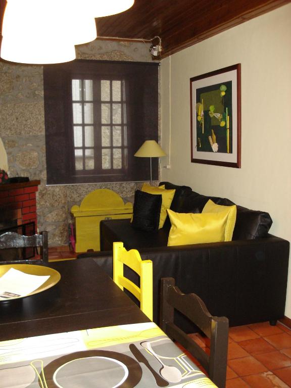a living room with a black couch and yellow pillows at Coreto Apartments in Sabugueiro