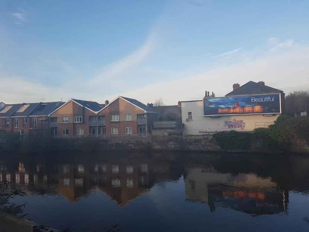 een gebouw met een billboard naast een waterlichaam bij Pia House in Dublin