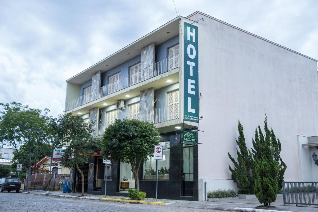 a white building with a sign that reads hotel at Hotel Pedra Bonita in Camaquã