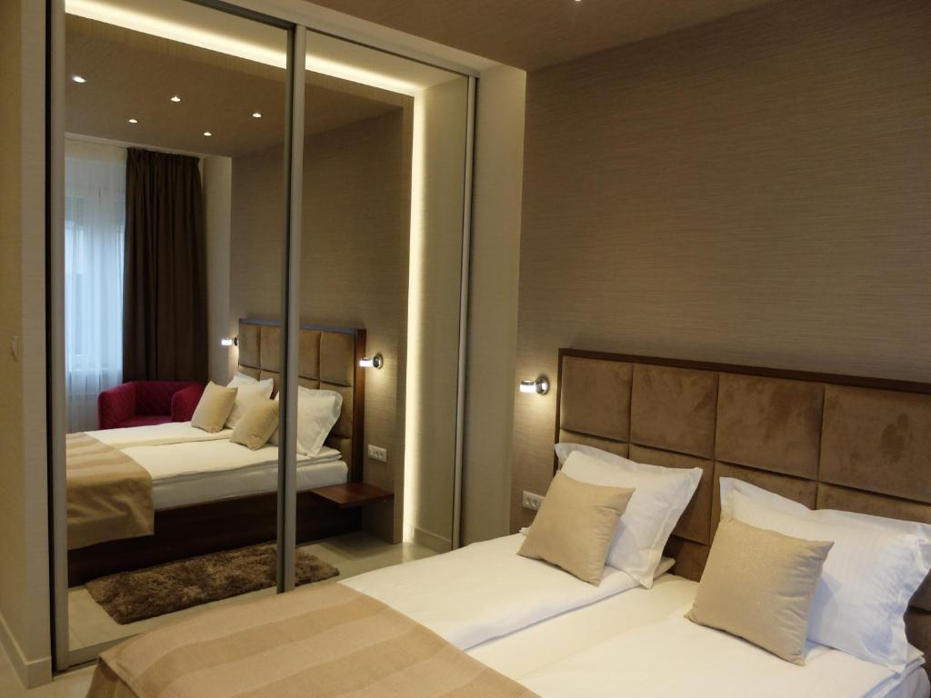 a hotel room with two beds and a mirror at Aria Royal Nusic apartment in Belgrade