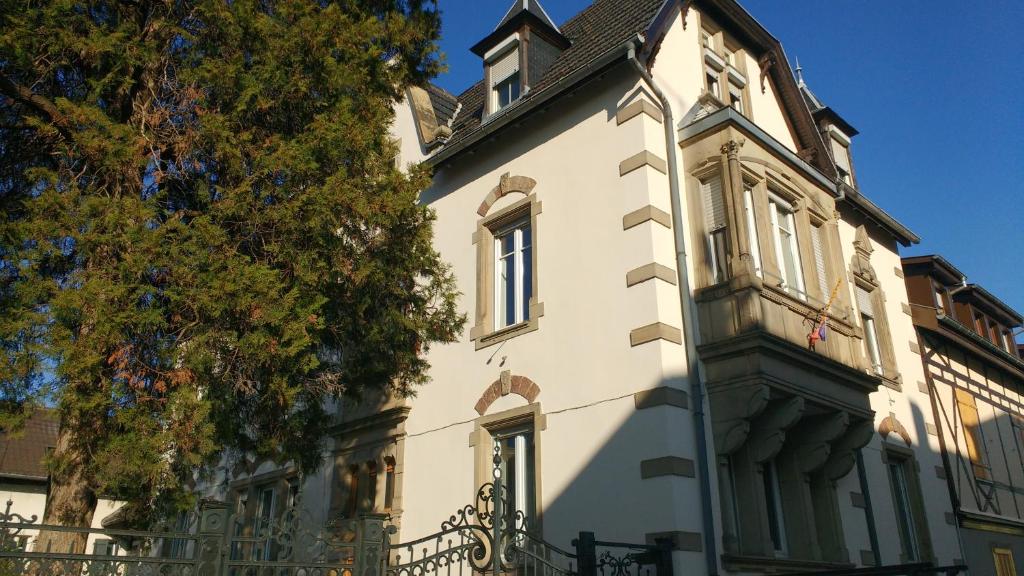 un grand bâtiment blanc avec un comble mansardé dans l'établissement Appartement Colmar Centre Le 4, à Colmar
