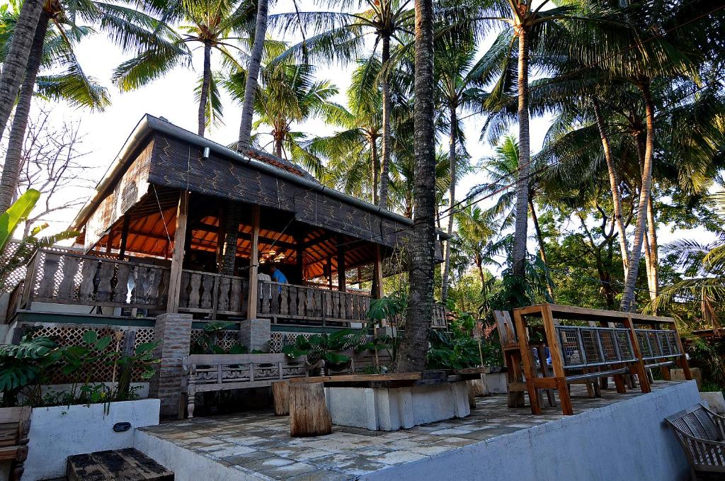 un edificio con palmeras delante en Desa Alamanis Resort Vila en Cirebon