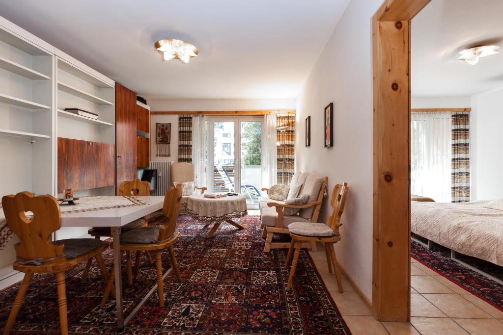uma sala de estar com uma mesa e cadeiras e uma cama em Chesa Derby 3 em Sankt Moritz-Bad