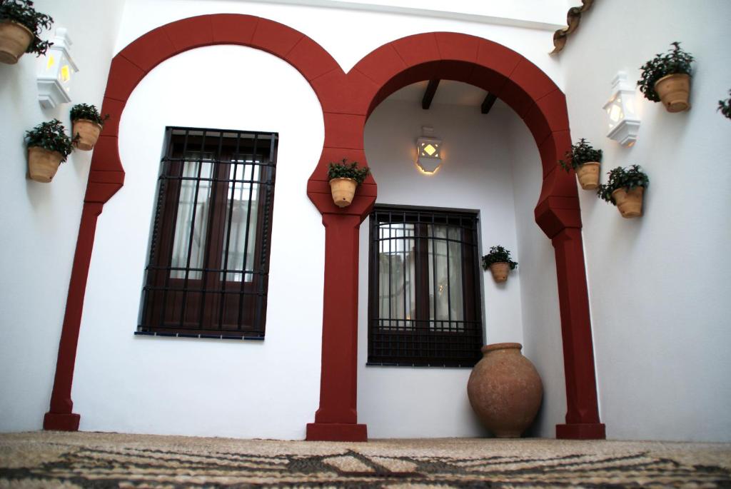コルドバにあるCasa Patio de los Arcosの赤いアーチと窓のある白い建物
