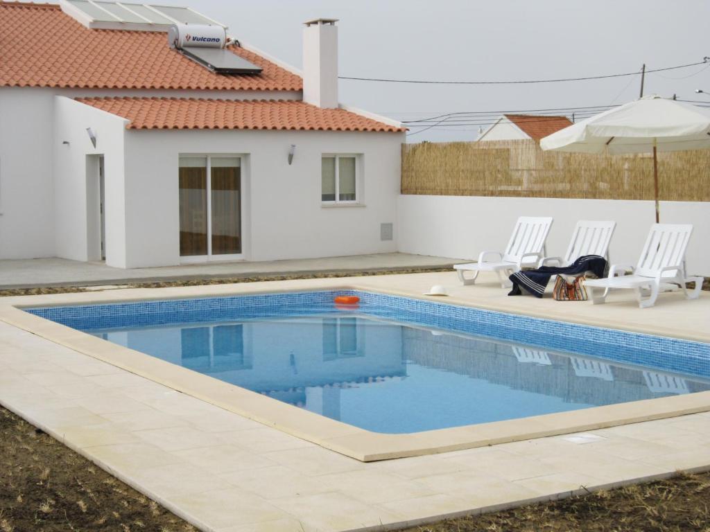 a swimming pool in front of a house at casa d'Azoia in Sesimbra