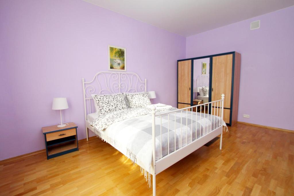 um quarto com uma cama branca e paredes roxas em TVST apartments on Tverskaya 6 em Moscou