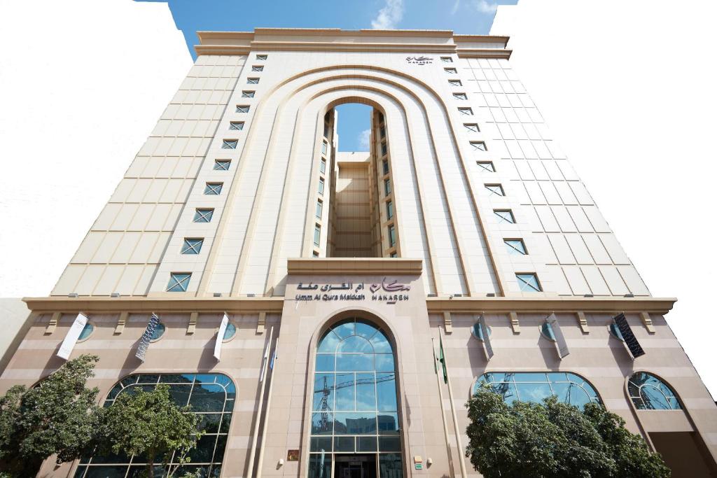 a tall building with an arch on the top of it at Makarem Umm Al Qura Hotel in Makkah